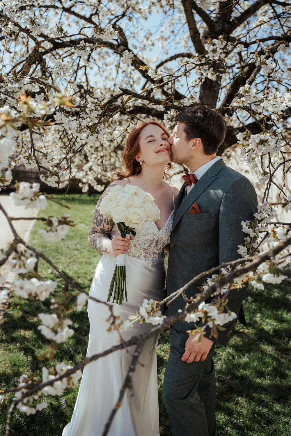 Emotionales Foto von einem sich küssenden Brautpaar im Park in Frankfurt